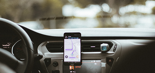 Get inspired food delivery Smartphone mounted on car dashboard displaying GPS navigation map while parked.